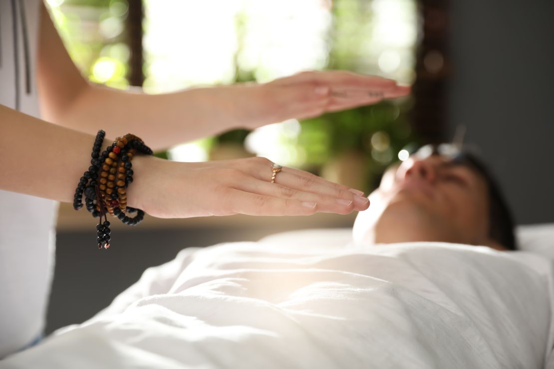 In the photo, Sophie performs Reiki healing on a client from Mount Holly, channeling energy to restore balance and harmony within the body’s natural energy systems. This Reiki massage session helps detoxify the body, alleviate pain, and promote deep relaxation, offering a calming and restorative experience.