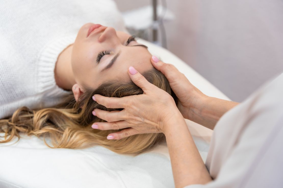 The image showcases Reiki healing through the flow of energy by placing hands on the scalp of a client from Mount Holly. The calm, focused approach highlights the professional care provided by skilled Reiki healers. This Reiki massage aims to balance energy and encourage deep relaxation, emphasizing the serene and therapeutic qualities of the session.